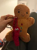 It is a gingerbread man and has attached to him 2 knotted red worms and also a p