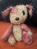Pink and purple and white small dog stuffy. Blue glass eyes and silky in her ear