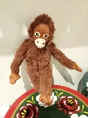 A small brown monkey (approx 15cm tall).  Labels on his back have been cut off s