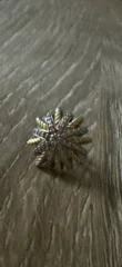A star shaped earring stud in gold and diamonds.