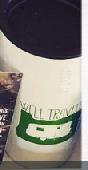 White Coffee Tumbler from Caravan Coffee (Oregon) with "Well Traveled" on in. No