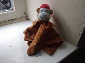 Brown monkey soother with red hat. 