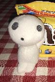 It’s white and around 5” Two grey eyes and round grey mouth. It has his arms rai