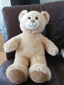 A tan coloured build a bear with no outfit and the I. D. Tag removed