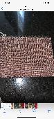 A small brown make up pouch with lipsticks and hand sanitizer inside 