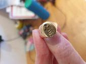 We found a gold signet ring with an inscription on the inside. We think it had b