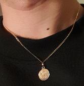 Been robbed of thin golden necklace having attached a round pendant with crab en