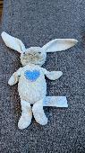 Small white cuddly bunny with a blue heart on chest and a rattle inside, approx 