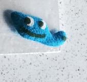 A very small (smaller than palm sized) blue soft toy in a "sleeping bag" in "Elm