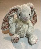 Cream soft cuddly bunny with bow on neck and floral fabric ears and feet. Well l