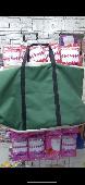 A green clothes bag has black handles and the bag is green mixed with brown and 