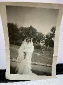 A polaroid of a woman in a wedding dress in a park