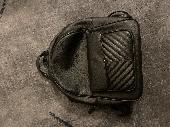 Small black backpack. (Ladies) Among many personal items is a set of keys with a