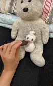 Lost stuffed polar bear with a silver ribbon around his neck. His paws and feet 