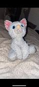 It is a white sassy cat, looks angry and has glittery ears. has sparkly blue eye