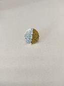 A round earring about 1cm in diameter. It is half gold and half silver in colour
