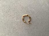 Gold ear ring found. Hoop type with indentations.